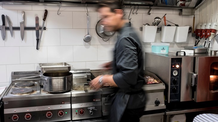 En man i rörelse i ett restaurang kök.